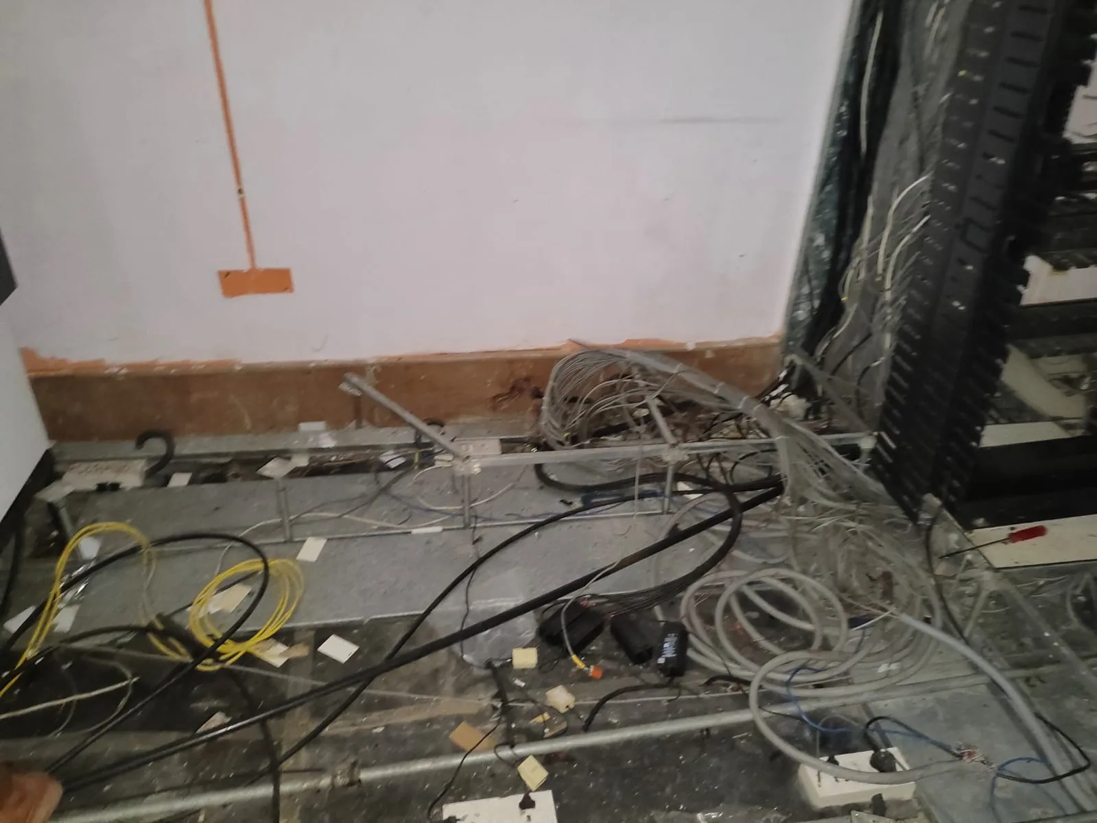 Systematic removal of data cables and backup systems indicating IT office decommissioning Taramani actions.